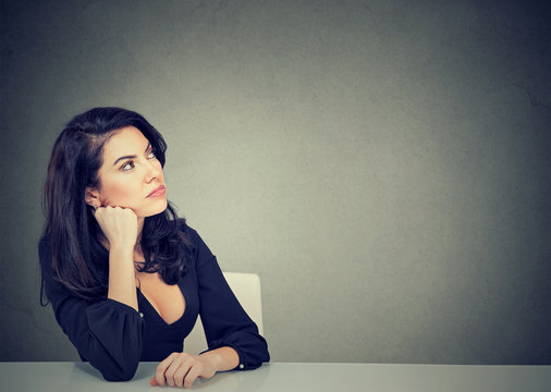 Thinking business woman sitting at desk