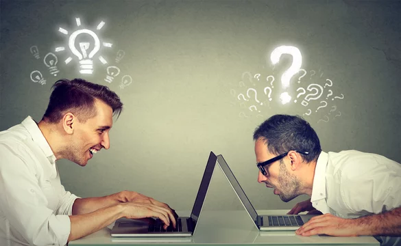 Two men using laptop computer one educated has bright ideas the other ignorant has questions