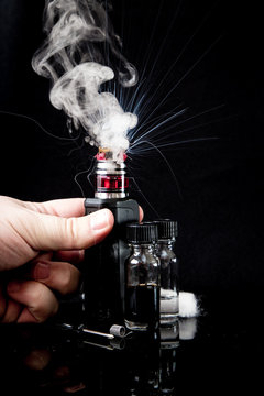 Electronic cigarette with 2 bottles and cloud of smoke