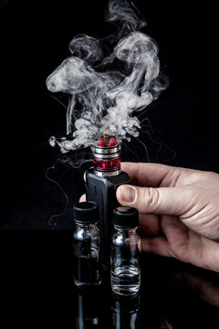 Electronic cigarette with 2 bottles and cloud of smoke