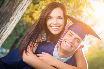 Happy Male Graduate in Cap and Gown and Pretty Girl Celebrate Outside.