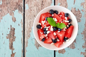 Summer salad with watermelon, blueberries and feta cheese, above view on a rustic blue wood...