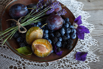Plums, blueberries and blackberries in a bowl on the table