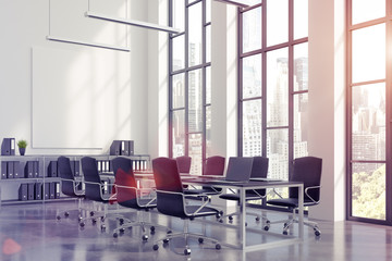 Meeting room interior with a long black table with laptops standing on it and a vertical poster on a white wall. 3d rendering, mock up, toned image