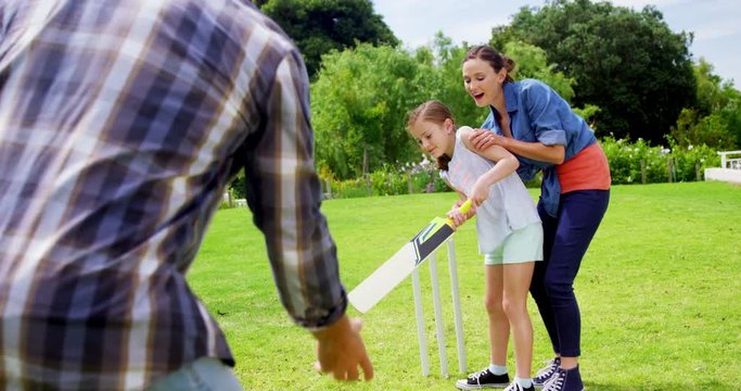 Happy family playing cricket