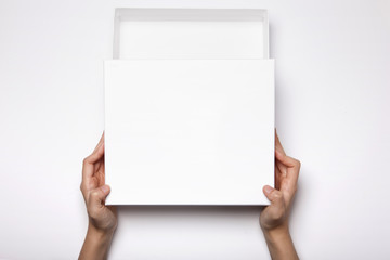 woman hand hold a white gift box isolated white.