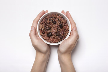 woman hand hold a rice bowl with red bean isolated white.