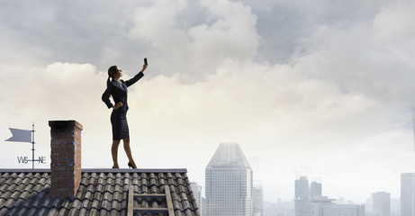 Fototapeta na wymiar Woman on roof doing selfie . Mixed media