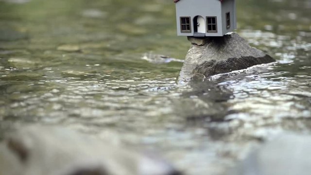 Model house on a rock and in the river.