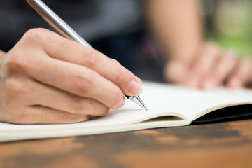 a woman holding a pen and writing