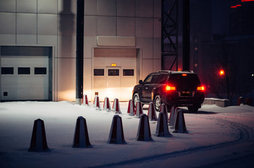 The black car calls into the automatic gate on a winter evening. Offroad car.