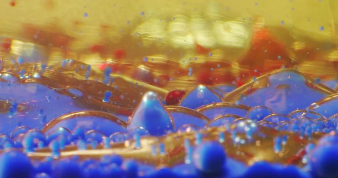 Stars wars of the planet.Color drops floating in oil and water over a colorful underground with oil painting effect. 4K.
