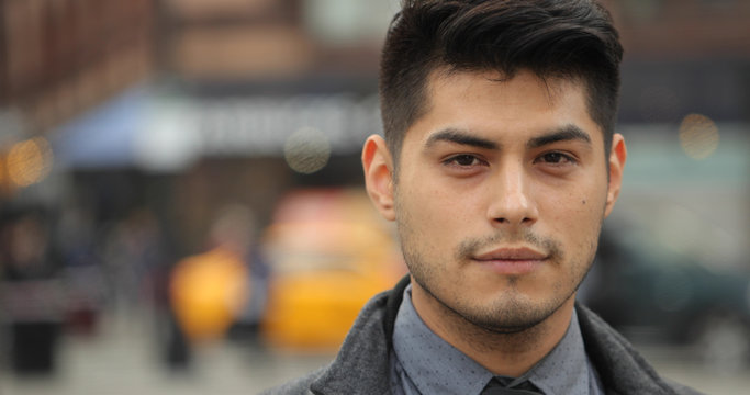 Young Hispanic Latino man in city face portrait