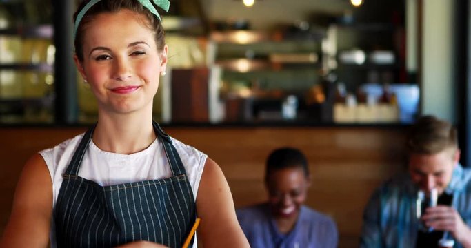 Portrait of waitress noting order on notepad