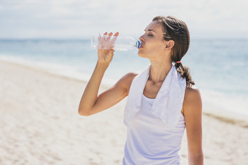 sporty woman drinking mineral water after workout