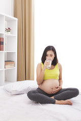 pregnant woman drinking a glass of fresh milk