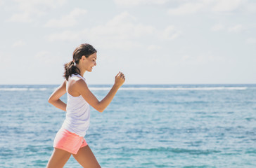 sporty woman jogging with skies and sea at the background