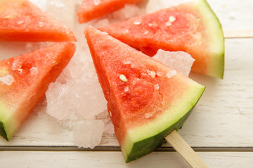 fresh cold watermelon popsicle on white wooden board
