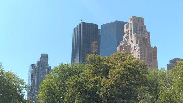 LOW ANGLE VIEW, CLOSE UP: Tall buildings, luxury real estate, offices, Trump International Hotel and Tower, modern glassy skyscrapers in Midtown Manhattan, New York City, view from the Central Park