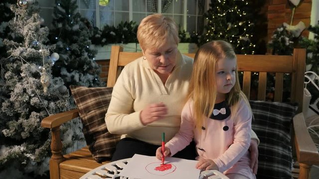 Grandma and Little Girl Drawing Chistmas Drawings Together Beautiful White Carved Table New Year Interior of Cosy Room Traditional Attributes of Christmas