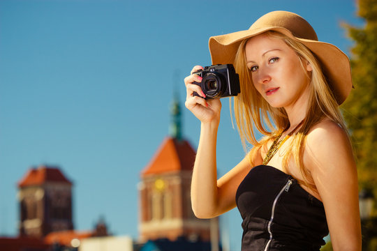 Beautiful elegant woman taking pictures with camera