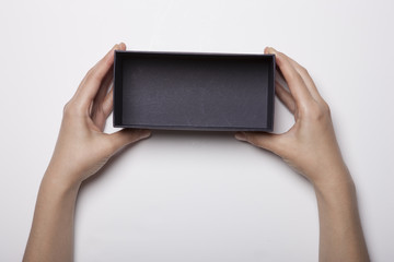 woman hand hold a black box isolated white.