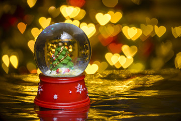 Christmas snow globe with xmas lights in background;