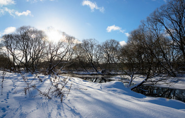 Sunny winter landscape with flowing river