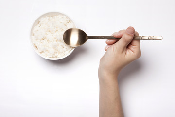 woman hand hold a spoon with rice isolated white.