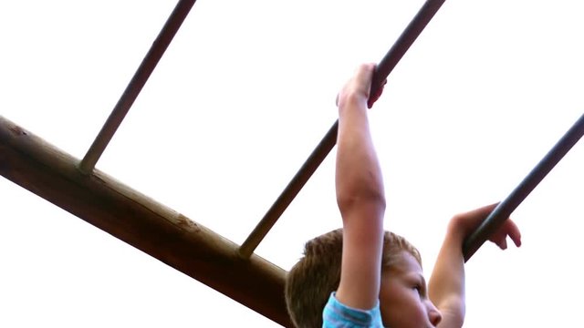 Boy playing on monkey bars in playground