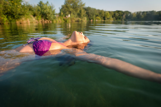 Woman swimming backwards in the lake