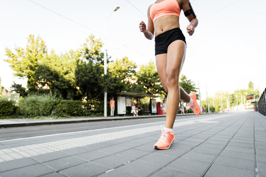 Cropped image of a fit woman athlete running outdoors