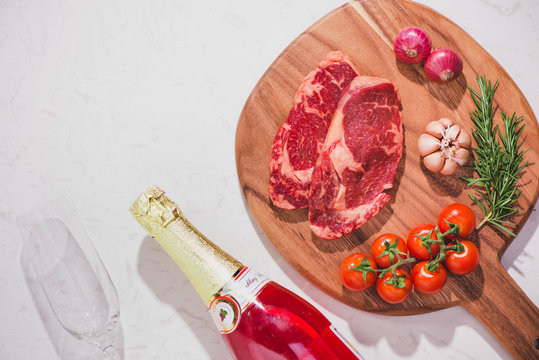 Raw beef on a cutting board  with spices and ingredients for cooking.