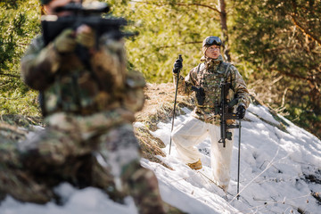 Fototapeta premium team of special forces weapons in cold forest. Winter warfare and military concept