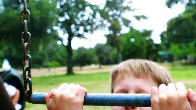 Boy hanging on a monkey bar in playground