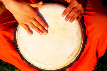 Young lady drummer with her djembe drum.