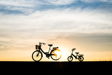Obraz premium Two Silhouette vintage bicycle at sunset.