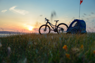 Biking in the hills at sunset with child trailer