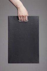woman hand hold a shopping paper bag, grey background.