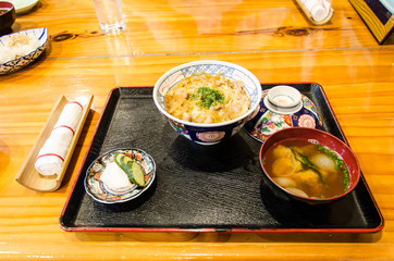 homemade oyakodon and rice in a bowl on wooden table