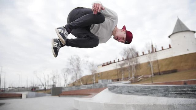 Street acrobatics - teenager jumps a flip in the park, parkour, slow motion