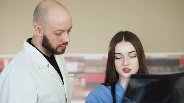 Medical team looking at x-ray together at hospital discuss 4k