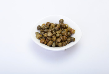 bowl with fresh capers isolated on white background.