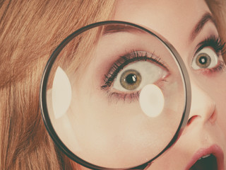 Woman holding magnifying glass investigating