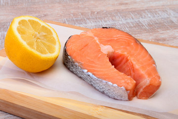 fresh raw salmon with spices and lemon on wooden cutting board. ready for cookin