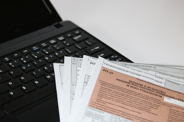 Naklejka na ściany i meble Open laptop and Tax forms