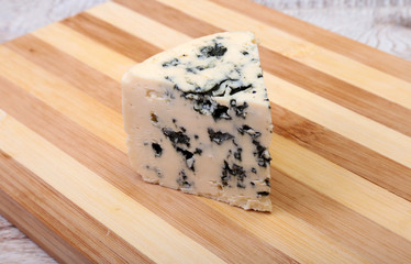 Plate with Tasty blue cheese on wooden table