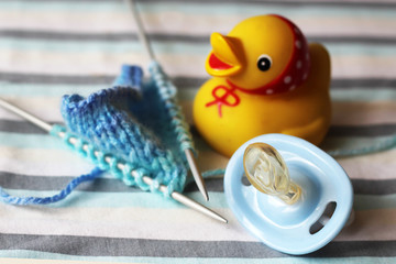 Children's pacifier and knitting needles.