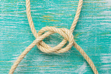Ropes tied with knots on turquoise background