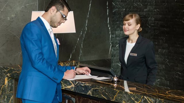 Young man of business recieving key at reception